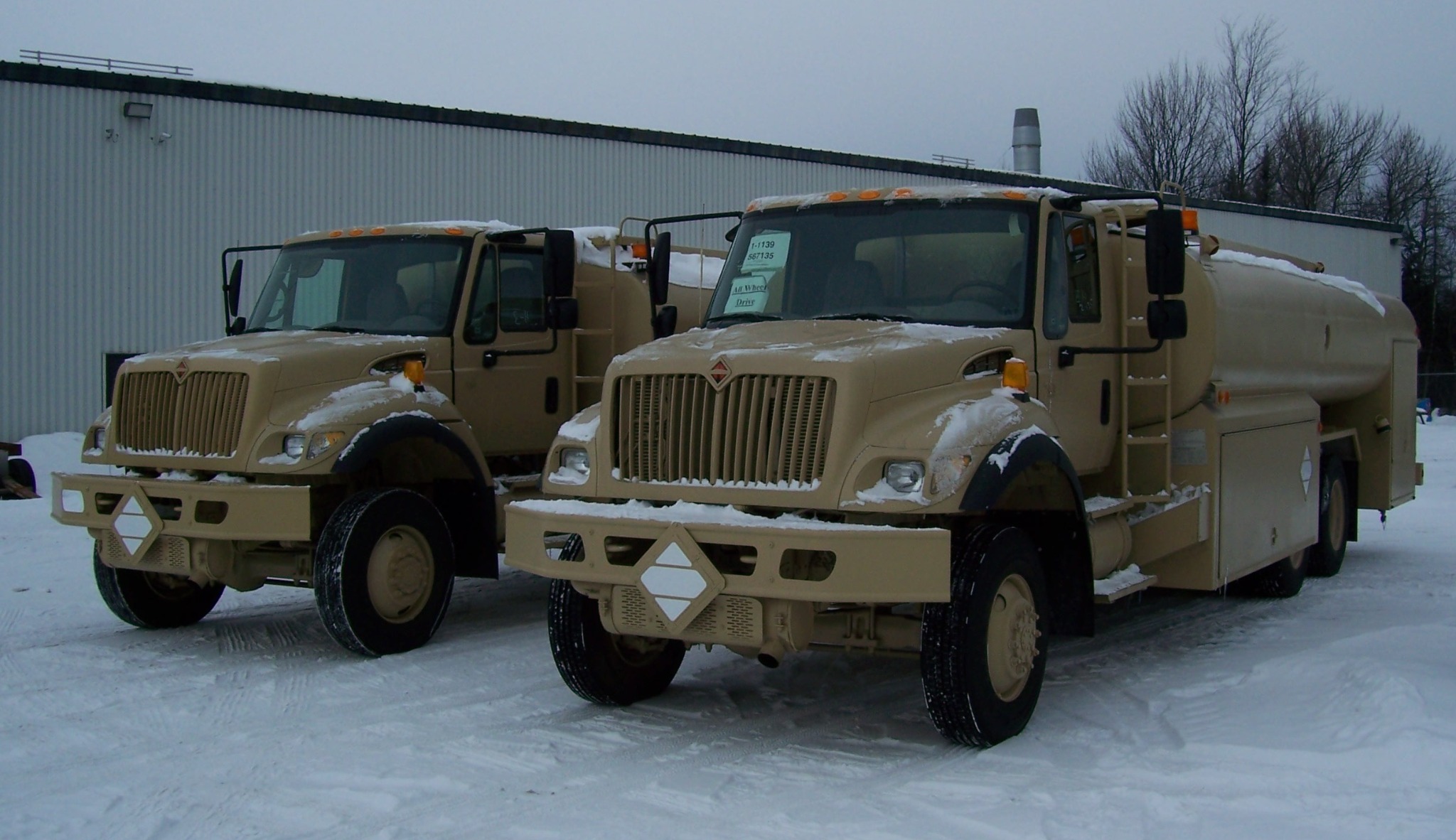 Aircraft refuelling trucks in snowy Montreal before shipment to Oman